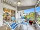 Charming screened-in patio with a glass table set, tiled floor, and lush green backyard at 27141 Racquet Cir, Leesburg, FL 34748