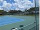 Bright blue and green tennis courts showcase an active lifestyle, protected by a sturdy fence at 27141 Racquet Cir, Leesburg, FL 34748