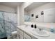 Bathroom featuring double sinks, stylish marble-patterned shower curtain, and neutral decor at 30422 Pintail Dr, Leesburg, FL 34748