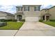 Two-story home featuring a two-car garage, neutral gray paint and minimalist landscaping in a suburban neighborhood at 30422 Pintail Dr, Leesburg, FL 34748
