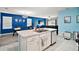 Open concept kitchen features an island with a stainless steel sink and white cabinetry and opens to dining area at 30422 Pintail Dr, Leesburg, FL 34748