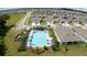 Aerial view of community pool with lounge chairs, landscaping, and nearby houses with modern designs at 30422 Pintail Dr, Leesburg, FL 34748
