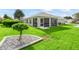 Exterior view of the screened-in patio and the lush green backyard at 3057 Saint Thomas Ln, The Villages, FL 32162