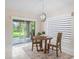 Cozy breakfast nook with a wooden table and chairs, a view to an outdoor patio and a bright window at 3057 Saint Thomas Ln, The Villages, FL 32162