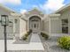 Inviting front entrance featuring a walkway lined with rocks and plants leading to a gray home at 3057 Saint Thomas Ln, The Villages, FL 32162
