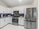 Updated kitchen featuring stainless steel appliances, white cabinetry and modern backsplash at 3057 Saint Thomas Ln, The Villages, FL 32162