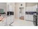 Well-lit kitchen featuring granite countertops, sleek appliances, and a convenient laundry area at 3057 Saint Thomas Ln, The Villages, FL 32162