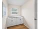 Clean laundry room featuring white cabinets, marble countertops, drawers and hardwood floors at 3057 Saint Thomas Ln, The Villages, FL 32162