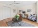 Bright living room featuring hardwood floors, a ceiling fan, and a cozy seating area at 3057 Saint Thomas Ln, The Villages, FL 32162
