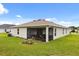 Well-maintained backyard featuring a screened patio, lush lawn, and tasteful landscaping at 3260 Casa Del Rey Ave, Kissimmee, FL 34746