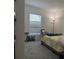 A simple bedroom with carpet, a window with blinds, and a lamp at 3260 Casa Del Rey Ave, Kissimmee, FL 34746