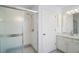 Bright bathroom featuring a walk-in shower with glass doors and a vanity with a sink at 33234 Kaylee Way, Leesburg, FL 34788