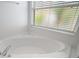 Close up on a pristine white soaking tub with modern fixtures, ideal for relaxation at 33234 Kaylee Way, Leesburg, FL 34788