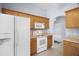 Kitchen with wood cabinets, white appliances, and tile flooring provides a clean, bright space at 33234 Kaylee Way, Leesburg, FL 34788
