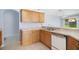 Functional kitchen featuring wooden cabinets, tile flooring, and a sink with bright natural light at 33234 Kaylee Way, Leesburg, FL 34788
