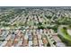 High-angle view of a neat residential community, featuring tree-lined streets and a beautiful lake at 3460 Idlewood Loop, The Villages, FL 32162