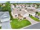 Aerial view of a well-maintained home with lush landscaping, a two-car garage, and a welcoming curb appeal at 3460 Idlewood Loop, The Villages, FL 32162