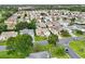 Panoramic aerial view of the property nestled in a vibrant residential community with lush greenery and mature trees at 3460 Idlewood Loop, The Villages, FL 32162