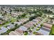 Expansive aerial view of a well-maintained residential neighborhood with lush green landscaping and serene lakes nearby at 3460 Idlewood Loop, The Villages, FL 32162