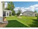 Spacious backyard with lush green grass, mature trees, and a screened-in lanai, perfect for relaxation at 3460 Idlewood Loop, The Villages, FL 32162