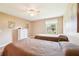 Comfortable bedroom with twin beds, a white dresser, and a window with views of the outdoors at 3460 Idlewood Loop, The Villages, FL 32162