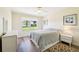Cozy bedroom featuring wood floors, a ceiling fan, and a large window at 3460 Idlewood Loop, The Villages, FL 32162