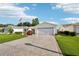 Charming single-story home featuring a well-manicured lawn, stamped concrete driveway, and attached two-car garage at 3460 Idlewood Loop, The Villages, FL 32162