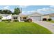 Inviting front yard with lush green lawn and attractive landscaping framing this charming single-story home at 3460 Idlewood Loop, The Villages, FL 32162