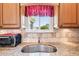 Close-up of kitchen sink featuring granite countertops, tile backsplash, and wooden cabinets at 3460 Idlewood Loop, The Villages, FL 32162