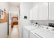 Laundry room featuring full size washer and dryer and white storage cabinets at 3460 Idlewood Loop, The Villages, FL 32162
