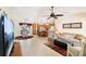 Open living room flowing into kitchen features tile flooring, ceiling fan, and comfortable seating area at 3460 Idlewood Loop, The Villages, FL 32162