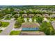 Wide aerial shot displaying a home's architecture, driveway, and the surrounding neighborhood with manicured lawns at 3604 Corsica Ln, Clermont, FL 34711