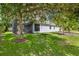 Lush backyard with green lawn, mature trees, screened lanai, and view of the house at 3604 Corsica Ln, Clermont, FL 34711