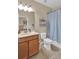 Neutral toned bathroom featuring a wooden vanity and shower/tub with curtain at 3604 Corsica Ln, Clermont, FL 34711