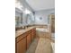 Bathroom featuring double sinks, granite countertops, a soaking tub, and a glass enclosed shower at 3604 Corsica Ln, Clermont, FL 34711