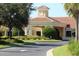 Beautiful clubhouse with a tile roof, well-manicured landscaping, and a fountain feature at 3604 Corsica Ln, Clermont, FL 34711