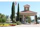 Community gated entrance with a tile roof guard house, water fountain, and lush landscaping at 3604 Corsica Ln, Clermont, FL 34711
