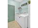 Well-lit laundry room with modern appliances and a light green painted door at 3604 Corsica Ln, Clermont, FL 34711