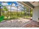 Screened-in patio with brick flooring overlooking a landscaped backyard with lush greenery at 3604 Corsica Ln, Clermont, FL 34711