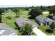 Aerial view of a home overlooking a golf course, lake, and lush green landscape at 3716 Eversholt St, Clermont, FL 34711