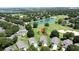 Aerial view of homes in a community with pond, golf course and mature trees at 3716 Eversholt St, Clermont, FL 34711