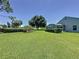 Backyard with a well-manicured lawn and landscaping that includes a partial view of the screened lanai at 3716 Eversholt St, Clermont, FL 34711