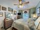 Cozy bedroom with a ceiling fan, window, and a combination of modern and wicker furniture at 3716 Eversholt St, Clermont, FL 34711