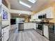 Modern kitchen with stainless steel appliances and white cabinetry, flowing into the living area at 3716 Eversholt St, Clermont, FL 34711