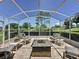 Screened lanai with brick flooring, fire pit, and comfortable seating with scenic views of the golf course at 3716 Eversholt St, Clermont, FL 34711