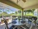 Screened lanai features a dining table, seating area, and beautiful views of the landscaped backyard at 3716 Eversholt St, Clermont, FL 34711