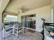 Patio area with exercise equipment, and a dining table looking out to a lush green space at 3716 Eversholt St, Clermont, FL 34711
