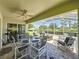 Covered lanai featuring a dining table and exercise equipment overlooking a green space at 3716 Eversholt St, Clermont, FL 34711