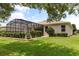 Beautiful backyard with manicured lawn and screened-in pool area at 4210 Arlington Ridge Blvd, Leesburg, FL 34748