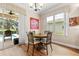 Cozy dining area with a round table, chandelier, and views of the screened-in pool at 4210 Arlington Ridge Blvd, Leesburg, FL 34748